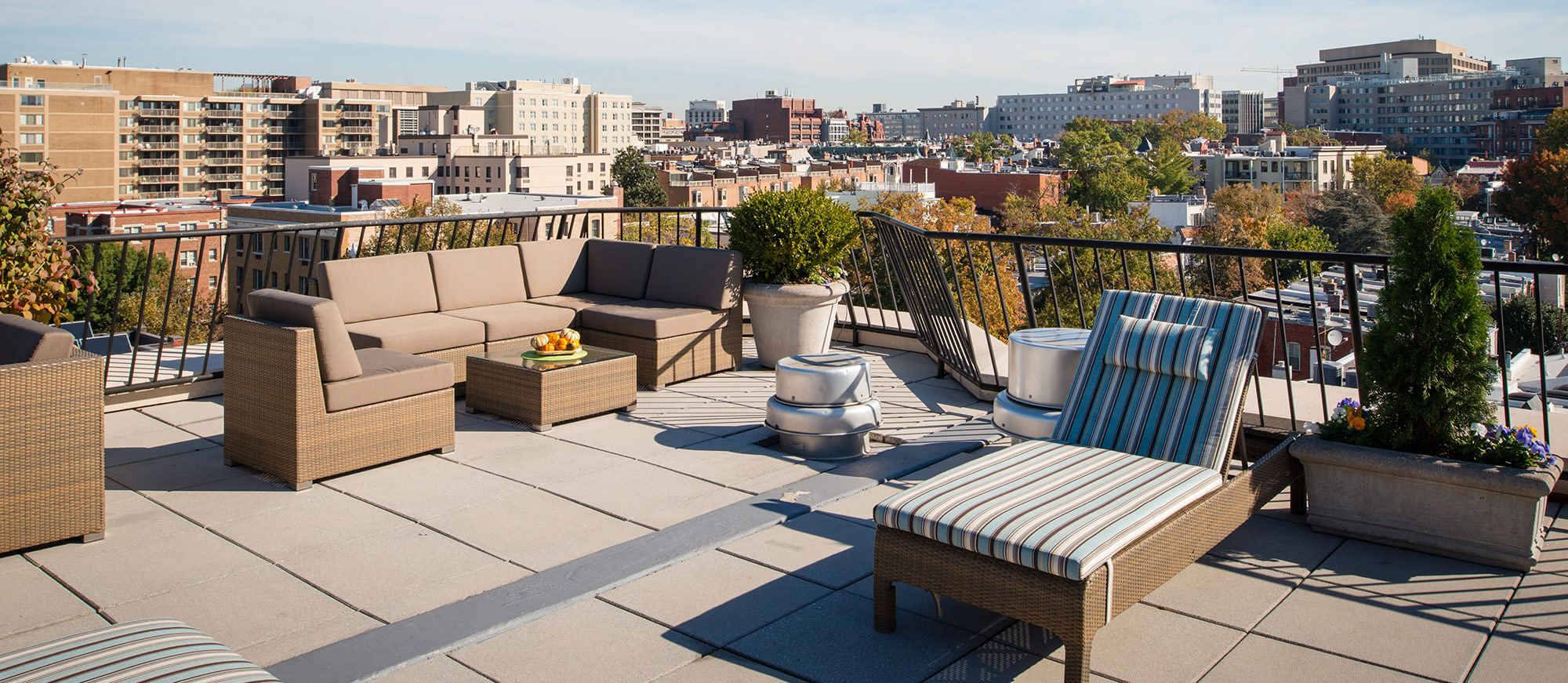 Outdoor deck with couch seating, suntanning beds and view of surrounding town